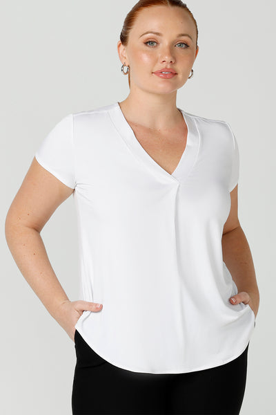 A good top for your capsule wardrobe, this V-neck tailored top in white bamboo jersey has short sleeves for summer style.  Shown on a size 12 woman, this is a great top for curvy women's work and casual wear. Made in Australia by ethical clothing brand, Leina & Fleur, shop ladies tops in petite to plus sizes online in their online fashion boutique.