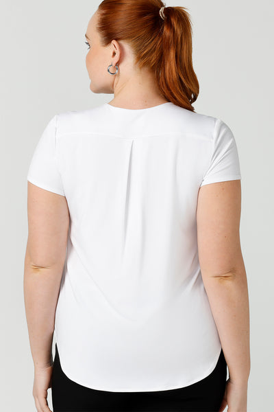 Back view of a good top for ladies capsule wardrobes, this V-neck tailored top in white bamboo jersey has short sleeves for summer style.  Shown on a size 12 woman, this is a great top for curvy women's work and casual wear. Made in Australia by ethical clothing brand, Leina & Fleur, shop ladies tops in petite to plus sizes online in their online fashion boutique.
