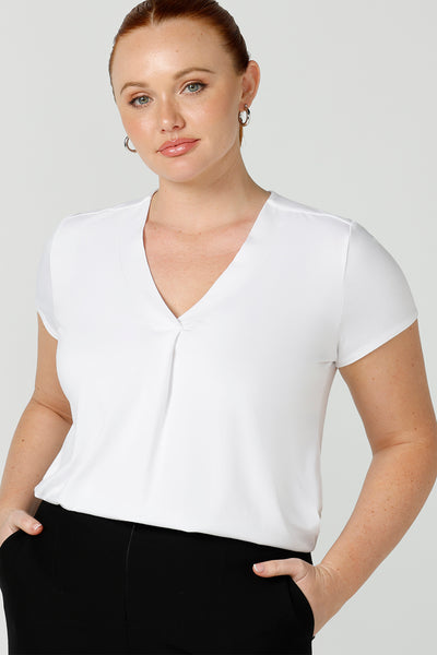 A good top for your capsule wardrobe, this V-neck tailored top in white bamboo jersey has short sleeves for summer style.  Shown on a size 12 woman, this is a great top for curvy women's work and casual wear. Made in Australia by online fashion brand, Leina & Fleur, shop ladies tops in petite to plus sizes online in their online clothing boutique.