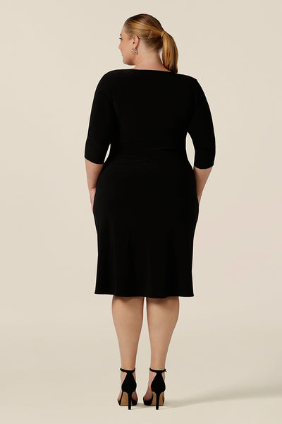 Back view of a great little black dress for evening and occasion wear! This is a fixed wrap, black jersey dress with 3/4 sleeves. Worn by a plus size, size 18 woman, shop this made-in-Australia dress in sizes 8 to 24.
