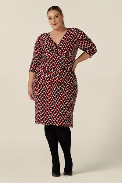 A plus size, size 18 woman wears a fitted wrap front dress with 3/4 sleeves by Australian fashion brand, Leina & Fleur. A good workwear dress, in printed jersey this is an easy-care dress for work wear capsule wardrobes.