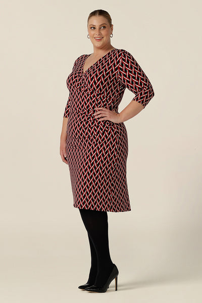 Side view of a plus size, size 18 woman wears a fitted wrap front dress with 3/4 sleeves by Australian fashion brand, Leina & Fleur. A good workwear dress, in printed jersey this is an easy-care dress for work wear capsule wardrobes.