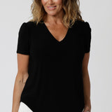 tailored short sleeve black top with v-neckline and shirttail hemline