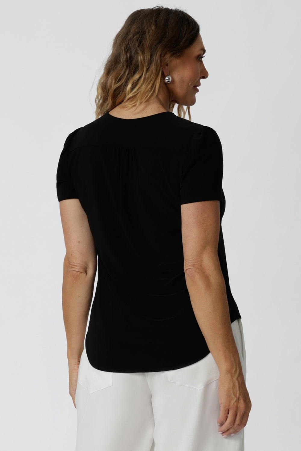 a tailored short sleeve black top with v-neckline and shirttail hemline, this summer top is a good top for off duty style.