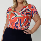 A good top for plus size women this tailored T-shirt top for summer, has a V-neck and short sleeves. Made in comfortable jersey, this printed top for women is worn by a size 18, curvy woman.  This casual top  is good for travel and cruise wear. Made in Australia by Australian clothes label, Leina & Fleur in sizes 8 to 24.