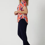 A good top to wear on a cruise, this  tailored T-shirt top for summer, is a V-neck top with short sleeves. Made in comfortable jersey, this printed top for women is worn by a size 12, over 40s woman.  Worn with tapered leg travel pants, this casual top  is good for travel and cruise wear. Made in Australia by Australian fashion brand, Leina & Fleur in sizes 8 to 24.