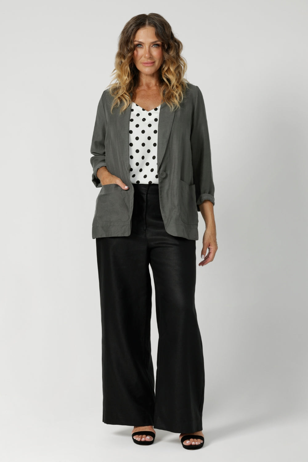 Over 40's model wears spotted cami paired with black work wear pants and heels and fern coloured blazer for an elevated workwear look. Australian made by clothing brand Leina & Fluer in inclusive sizing ranging from plus sized to petite in an 8-4.