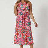 Over 40's woman wears v neck midi summer ready dress. The abstract tropical print of the dress embodies the essence of a resort lifestyle and beach getaways. Leina & Fleur have a collection of Indian Summer printed garments made of the same stretchy crepe jersey in sizes 8-24.