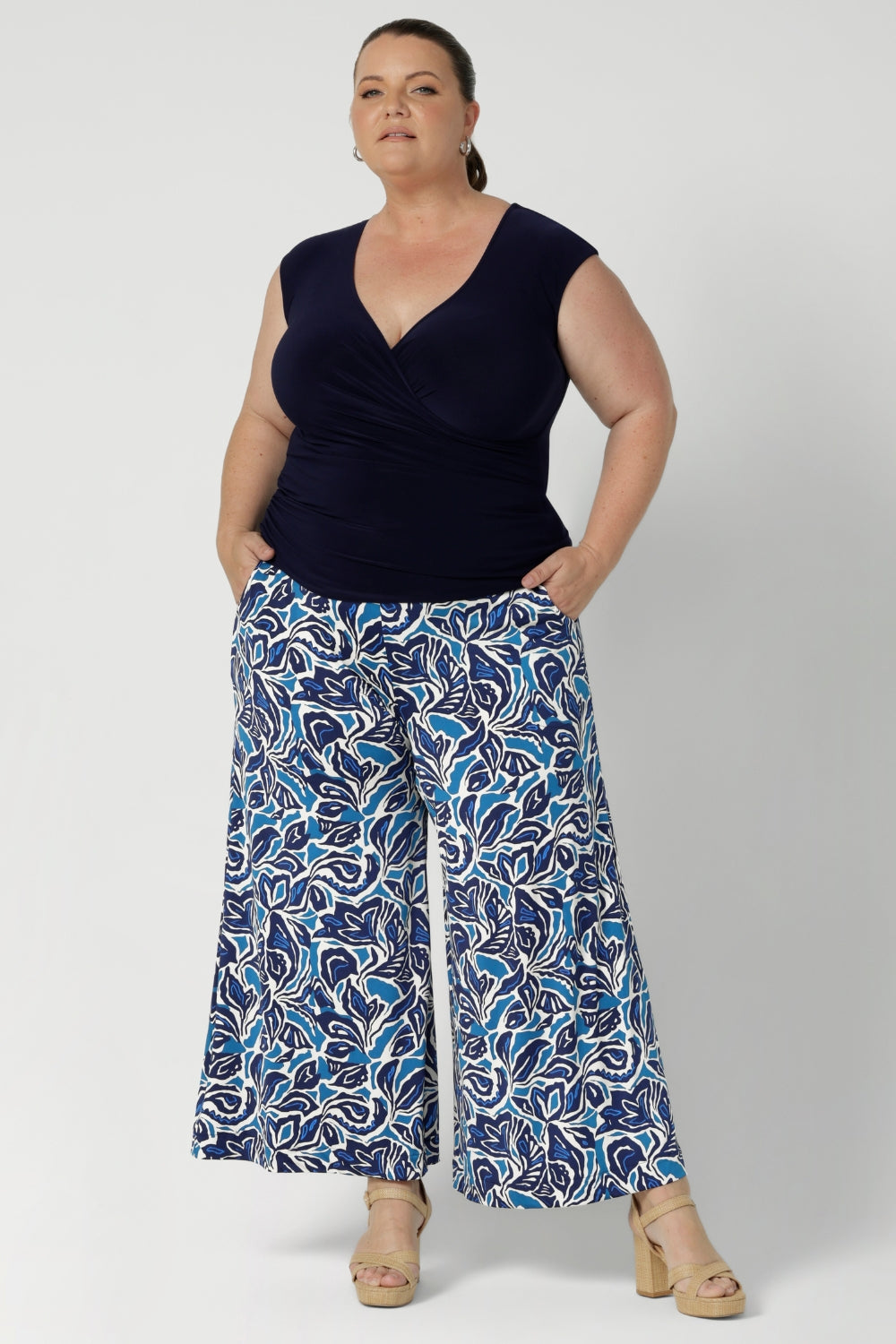 A curvy woman wears the Finely top in Navy paired with printed Dany Culotte. Fixed wrap style perfect for corporate to casual wear. Made in Australia for women size 8 - 24.