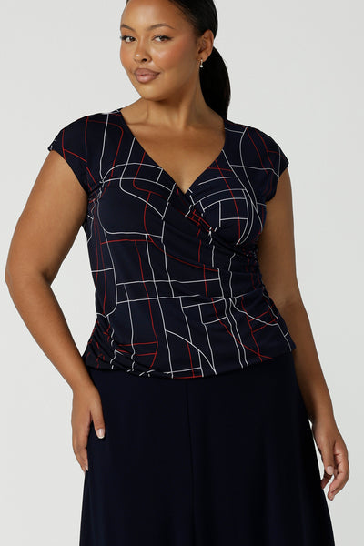 Size 16 woman wears a Finley Top in Navy abstract. Fixed wrap top with a geometric pattern. Styled back with a Navy skirt. Comfortable corporate wear for women. Made in Australia for women size 8 - 24.