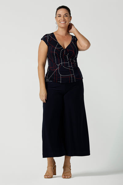 Size 12 woman wears a Finley Top in Navy abstract. Fixed wrap top with a geometric pattern. Styled back with a Navy skirt. Comfortable corporate wear for women. Made in Australia for women size 8 - 24.