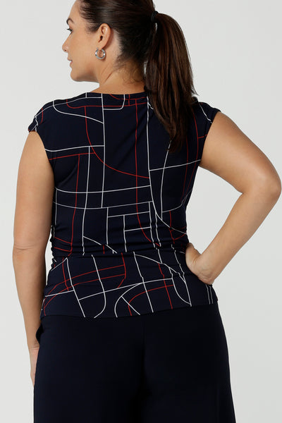 Back view of a size 12 woman wears a Finley Top in Navy abstract. Fixed wrap top with a geometric pattern. Styled back with a Navy skirt. Comfortable corporate wear for women. Made in Australia for women size 8 - 24.