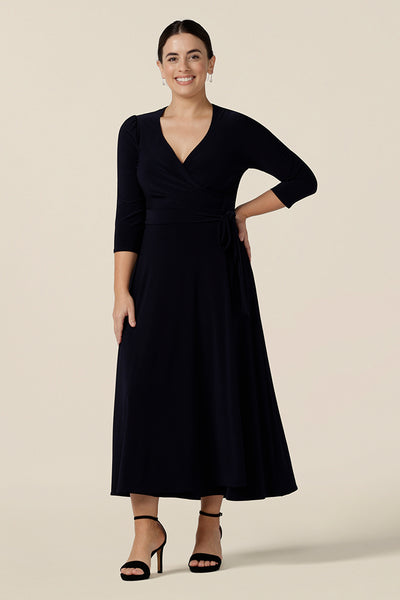 Shown for petite height women, this is a navy blue wrap dress with 3/4 sleeves. With a full, midi skirt, this jersey dress is a good dress for evening and occasion wear. Made in Australia, shop dresses in sizes 8 to 24.