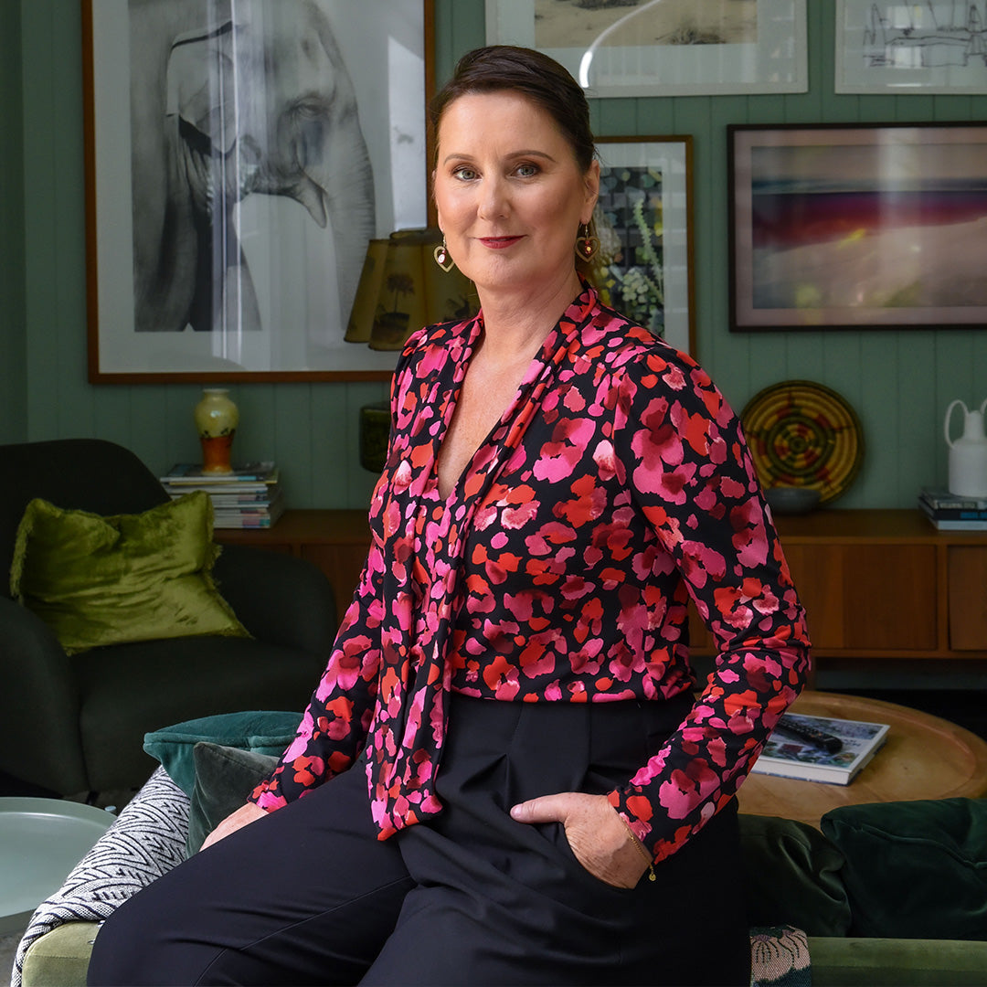 Founder of Australian-made women's clothing label, Leina and Fleur, New Zealand-born Fleur Richardson wears a long sleeve, V-neck top with neck ties and tailored, tapered leg pants. 