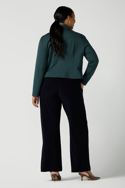 Size 16 woman wears the Garcia Jacket in Alpine styled back with the Vida Top in Amethyst. A v-neckline style with 3/4 sleeves. Styled back with Monroe Pant in Navy. A comfortable corporate work pant. Size 8 - 24.