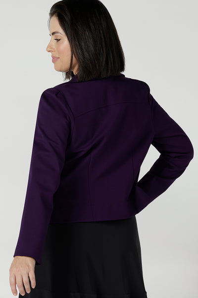 Back view of a size 10 woman wearing the Garcia jacket in Alpine, a amethyst purple jacket with tailored details in a soft stretch ponte jersey. Comfortable and stylish workwear for women. Styled back with Berit skirt in Charcoal. Made in Australia for women size 8 - 24,