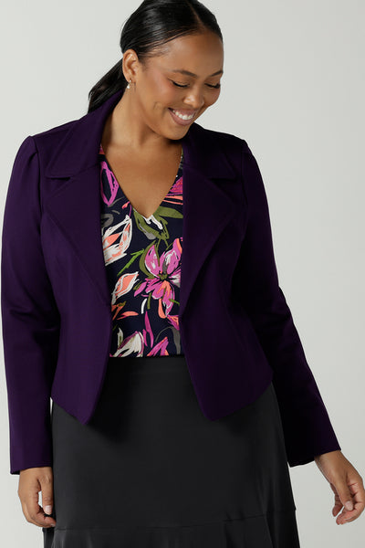 Size 16 woman wears the Garcia Jacket in Alpine. A Amethyst jacket made in Australia for women. Size 8 - 24. Styled back with a floral Vida top and charcoal berit skirt. Comfortable and Stylish workwear for ladies.