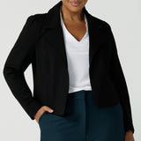 Size 16 woman wears the Garcia Jacket in Black. Tailored design with collar and comfortable stretch. Comfortable and stylish workwear for women. Size inclusive fashion and made in Australia for women size 8 - 24. Styled back with Yael wide leg pants in Petrol. 