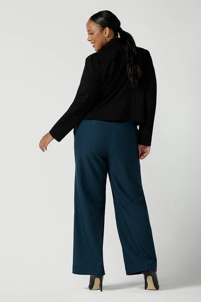 Back view of a size 16 woman wears the Garcia Jacket in Black. Tailored design with collar and comfortable stretch. Comfortable and stylish workwear for women. Size inclusive fashion and made in Australia for women size 8 - 24. Styled back with Yael wide leg pants in Petrol.