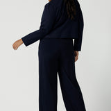Back view of view of a size 16 woman wears the Garcia Jacket in Navy. Stylish comfortable workwear for women. Tailored with dry touch tech stretch jersey. Made in Australia size 8 - 24.