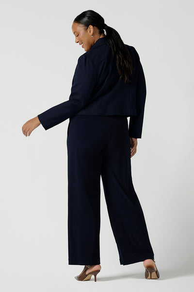 Back view of view of a size 16 woman wears the Garcia Jacket in Navy. Stylish comfortable workwear for women. Tailored with dry touch tech stretch jersey. Made in Australia size 8 - 24.