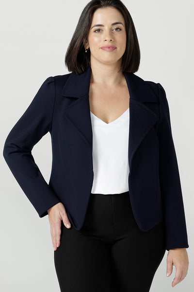 Size 10 woman wears a Navy jacket in a stylish tailored jacket. Styled back with a white v-neck bamboo top and black brooklyn pants. Made in Australia for women size 8 - 24.