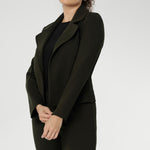 The cropped silhouette is complemented by double-layered front panels and refined collar and notch lapels, finished with subtle topstitch detailing for a sophisticated edge. A structured shoulder yoke and back darts create a flattering, contoured fit.