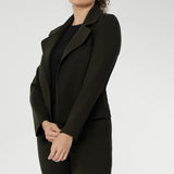 The cropped silhouette is complemented by double-layered front panels and refined collar and notch lapels, finished with subtle topstitch detailing for a sophisticated edge. A structured shoulder yoke and back darts create a flattering, contoured fit.