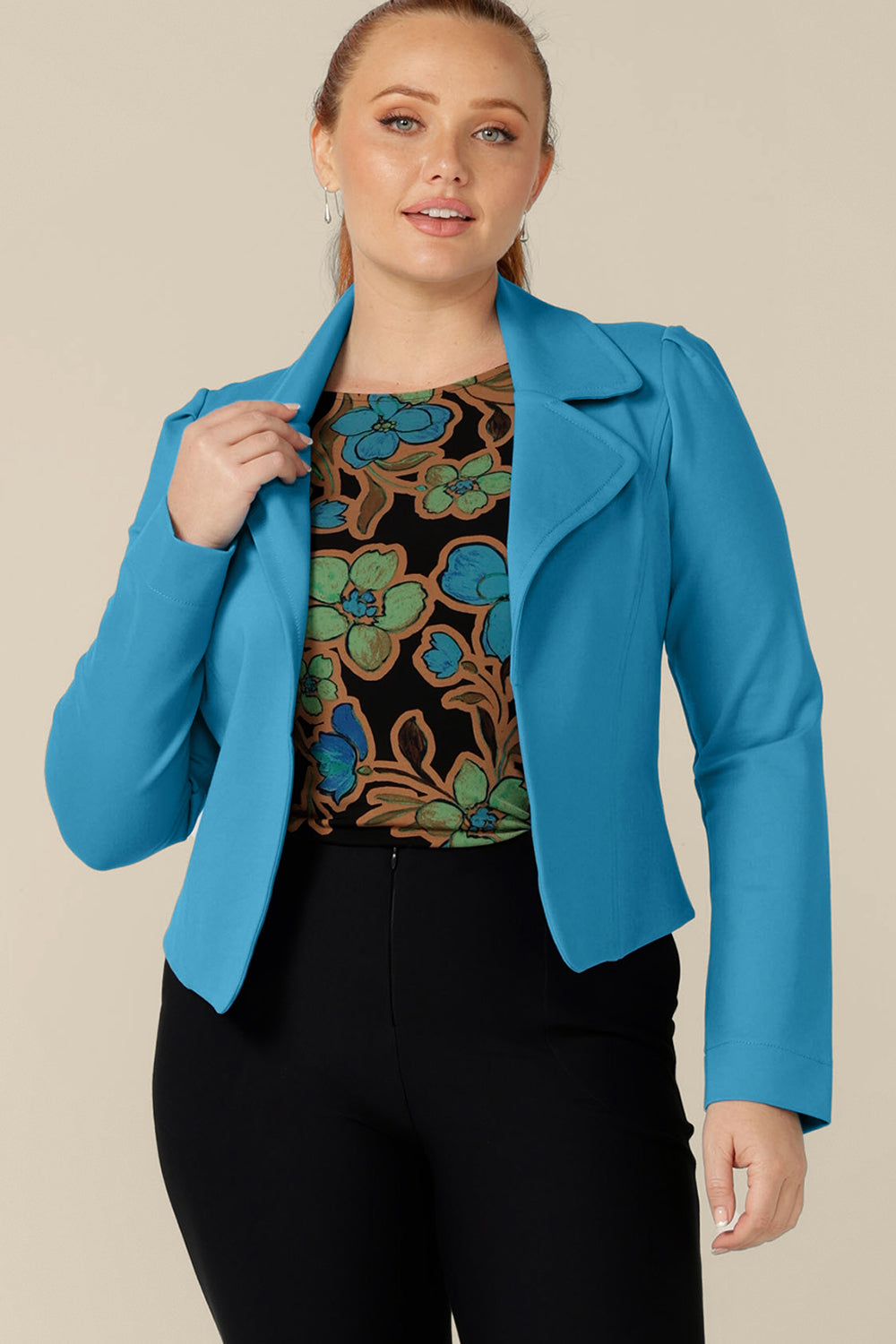 A size 12, curvy figure woman wears the Garcia Jacket in Opal blue ponte fabric by Australian and New Zealand women's clothing label, L&F. Featuring collar and notch lapels and long sleeves, this open-fronted jacket is good for workwear and casual wear.