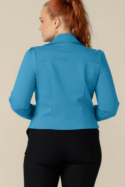 Back view of a curvy, size 12 woman wearing the Garcia Jacket in Opal blue ponte fabric by Australian and New Zealand womenswear label, L&F. Featuring collar and notch lapels and long sleeves, this open-fronted jacket is good for work and casual wear.