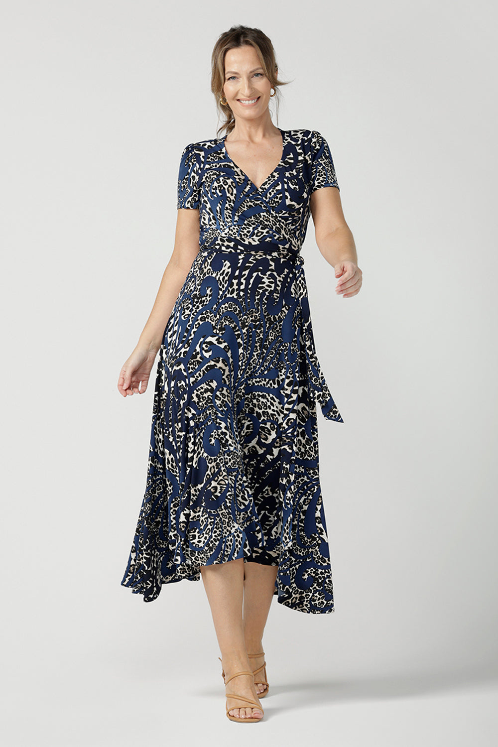 A size 10 over 40 year old woman wears a animal print jersey wrap dress with tailored godets in the skirt. A good wrap dress for summer, shop Australian-made plus size wrap dresses online at Australian fashion brand Leina & Fleur.