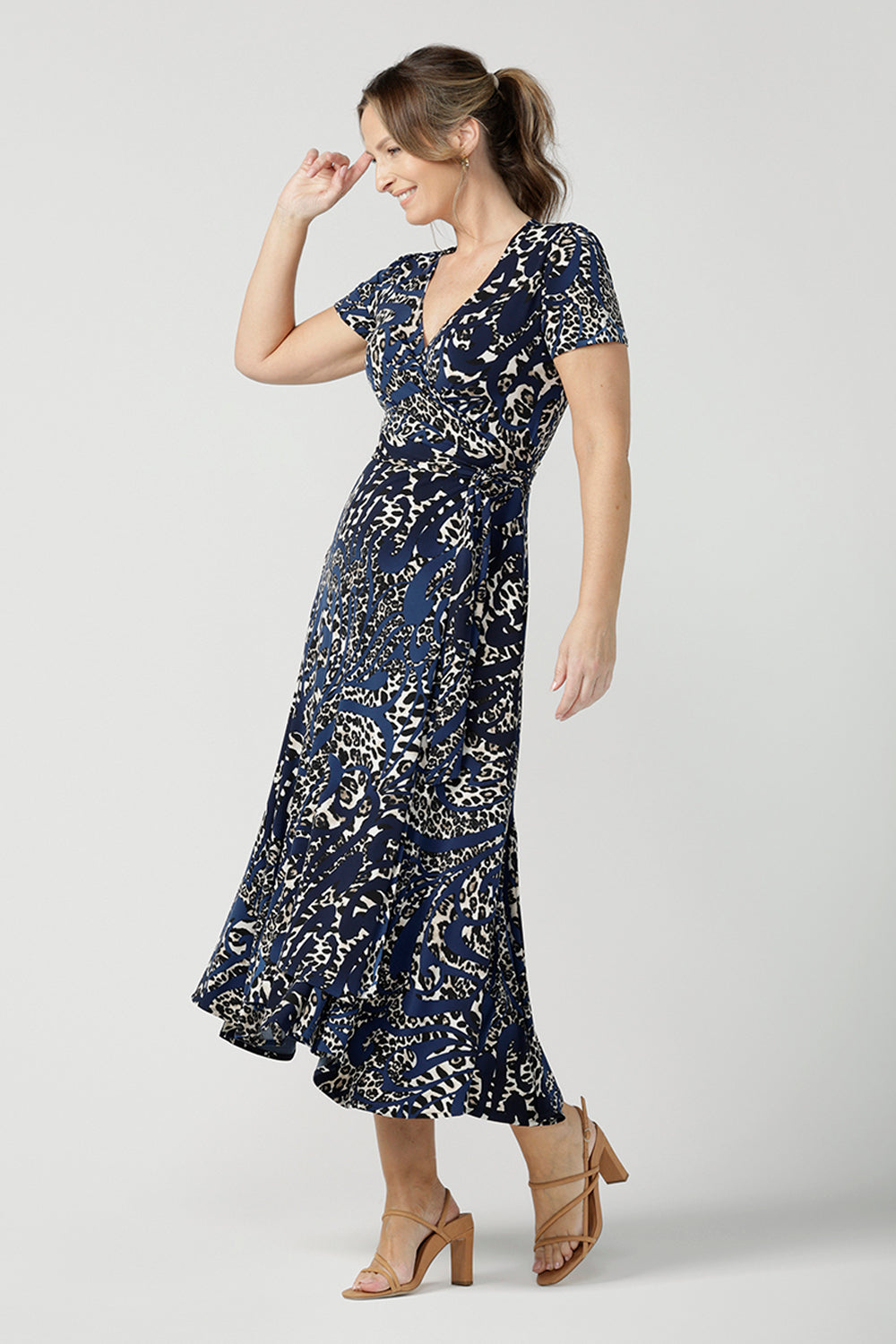 A size 10 over 40 year old woman wears a animal print jersey wrap dress with tailored godets in the skirt. A good wrap dress for summer, shop Australian-made plus size wrap dresses online at Australian fashion brand Leina & Fleur.