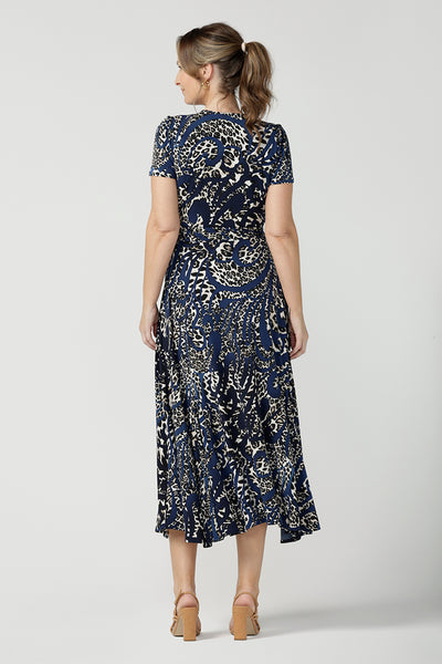 Back view of a size 10 over 40 year old woman wearing a animal print jersey wrap dress with tailored godets in the skirt. A good wrap dress for summer, shop Australian-made plus size wrap dresses online at Australian fashion brand Leina & Fleur.