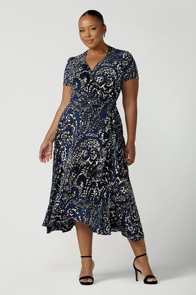 A size 18 plus size woman wears a animal print jersey wrap dress with tailored godets in the skirt. A good wrap dress for summer, shop Australian-made plus size wrap dresses online at Australian fashion brand Leina & Fleur.