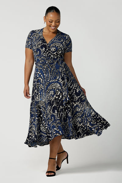 A size 18 plus size woman wears a animal print jersey wrap dress with tailored godets in the skirt. A good wrap dress for summer, shop Australian-made plus size wrap dresses online at Australian fashion brand Leina & Fleur.