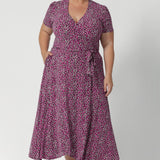 Plus size woman wears printed pink dress with tailored featured including double-layer back bodice for extra support and extended waist ties that allow for an adjustable fit. The short sleeves are beautifully finished with gathering at the sleevehead, giving the dress a fresh, feminine feel. Available in sizes 8-24.