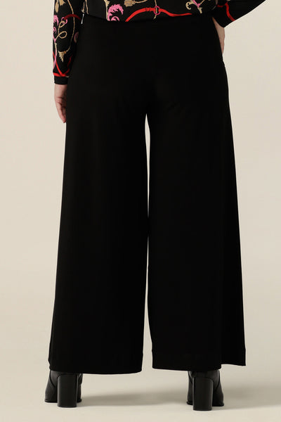 Back view of black wide leg pants with pockets, shown in a size 10. These pull-on, easy care pants are comfortable for your everyday workwear capsule wardrobe. Shop these Australian-made black trousers online in sizes 8 to 24, petite to plus sizes.