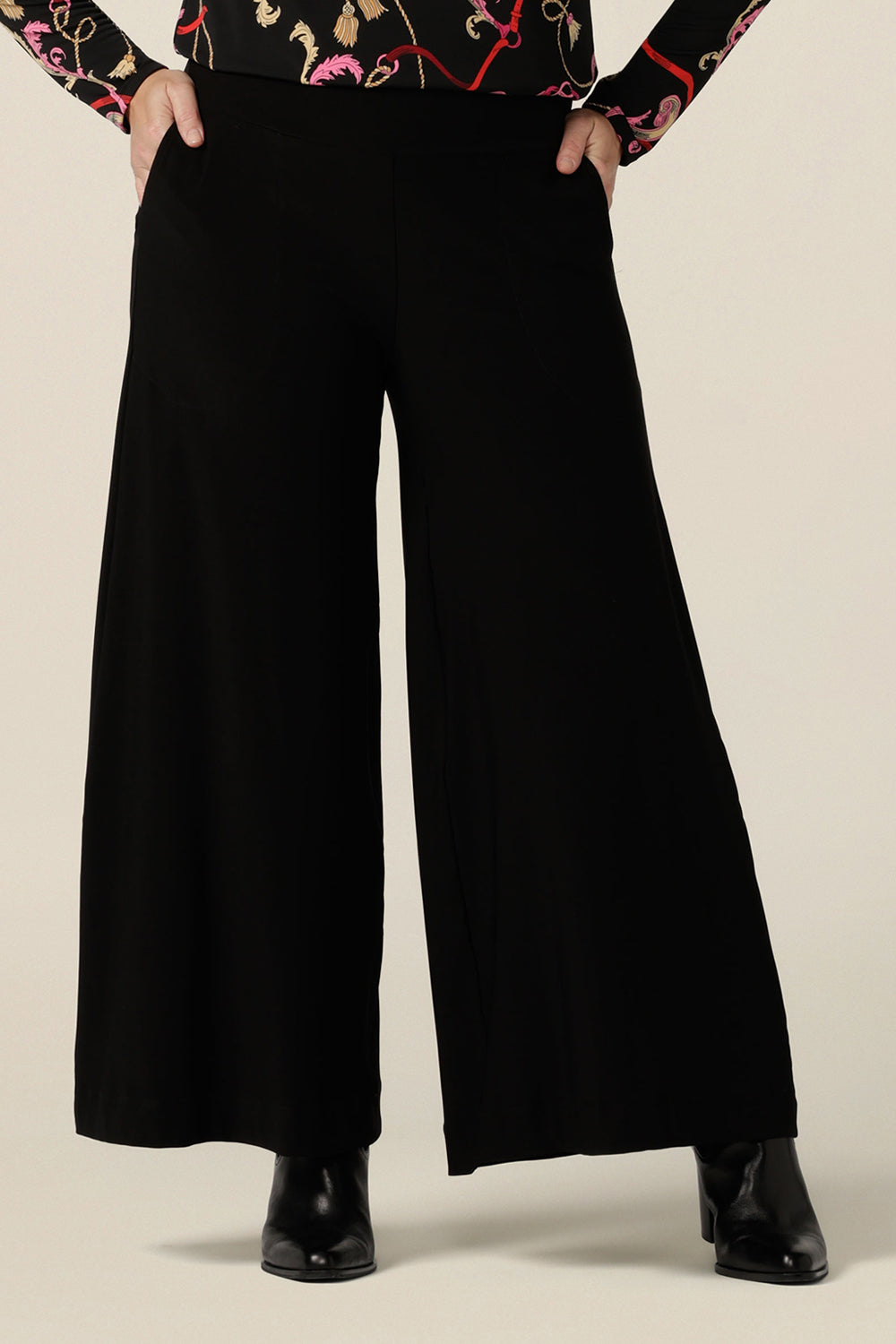 Black wide leg pants with pockets, shown in a size 10. These pull-on, easy care pants are comfortable for your everyday workwear capsule wardrobe. Shop these Australian-made black trousers online in sizes 8 to 24, petite to plus sizes.