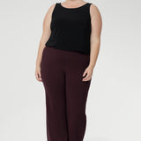 The Harlee Reversible Top—a must-have essential that effortlessly blends comfort, style, and practicality. Crafted from our signature dry-touch stretch jersey. Plus size model wears her reversible cami with boot leg style pants in the wine colour. 