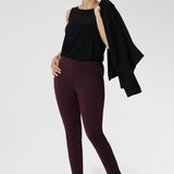 Versatility with the Harlee Reversible Top—a must-have essential that effortlessly blends comfort, style, and practicality. Crafted from our signature dry-touch stretch jersey, this everyday piece features a chic boat neckline and a sleek, streamlined silhouette. Over 30's woman wears her cami tucked into wine coloured skinny leg pants and sneakers. 