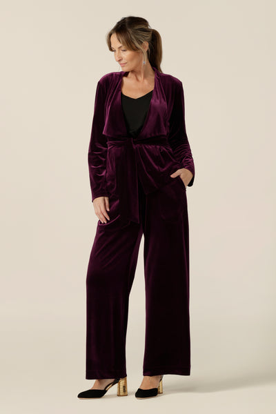 Occasionwear dressing at its finest, this soft tailoring jacket in red wine velour adds effortless glamour to black cocktail wear. Shown here over a black cami top and slim leg black trousers, this open front, soft collared evening jacket is made in Australia in sizes 8 to 24.