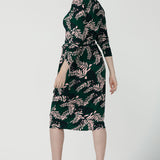 Back view of A size 10 model wears the Alpine Fern Heather dress in jersey. Made in Australia for women size 8 - 24. Fern green with leaf print all over.