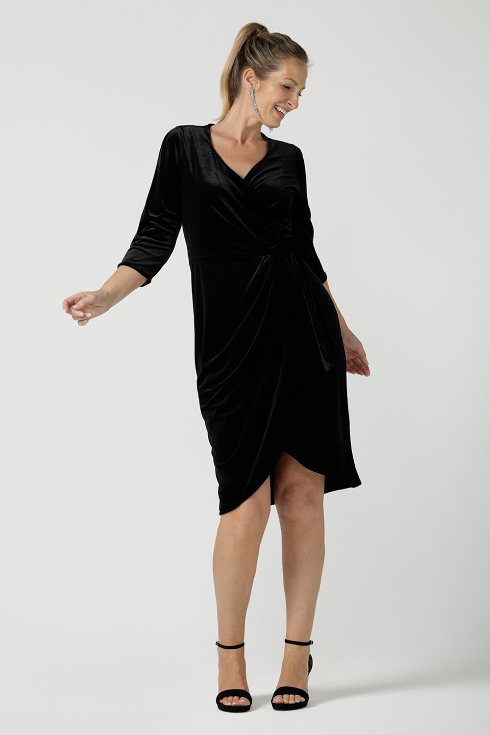 Size 10 model wears the Hedy dress in Black. A velour functioning wrap dress with a tulip skirt and draped front. Up Late evening wear for event dressing. Size inclusive sustainable fashion made in Australia size 8 - 24.