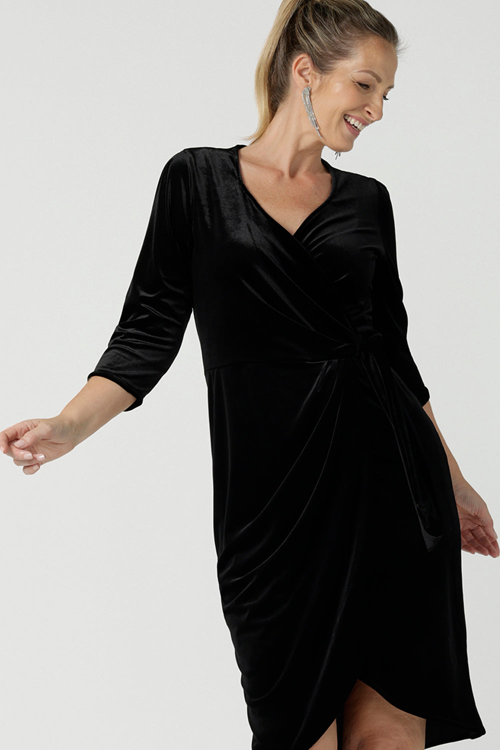 Close up a size 10 model wears the Hedy dress in Black. A velour functioning wrap dress with a tulip skirt and draped front. Up Late evening wear for event dressing. Size inclusive sustainable fashion made in Australia size 8 - 24.