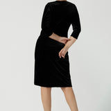 Back view of a size 10 model wears the Hedy dress in Black. A velour functioning wrap dress with a tulip skirt and draped front. Up Late evening wear for event dressing. Size inclusive sustainable fashion made in Australia size 8 - 24.