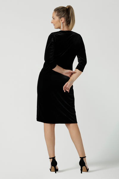 Back view of a size 10 model wears the Hedy dress in Black. A velour functioning wrap dress with a tulip skirt and draped front. Up Late evening wear for event dressing. Size inclusive sustainable fashion made in Australia size 8 - 24.