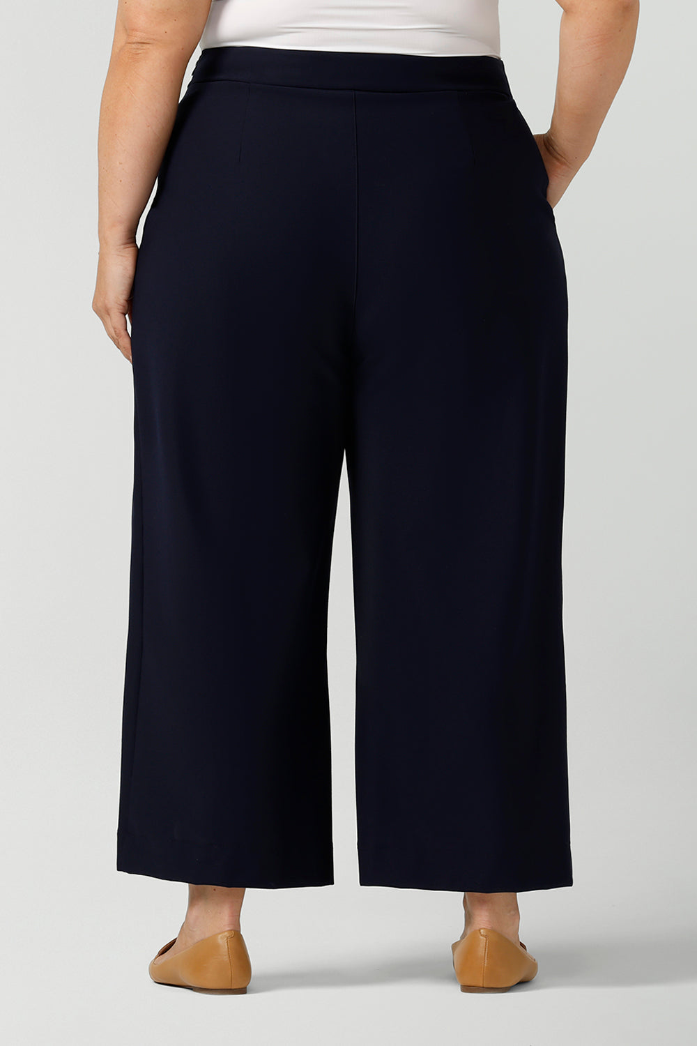 Back view of wide-leg, cropped length Hollis Culotte Pant in Navy blue. Featuring front pleats, side pockets and stretch jersey fabric these are comfortable, plus size work pants. This tailored trouser delivers quality office wear to women in sizes 8 to 24. - shop now at Australian ladies clothing brand, Leina & Fleur's online boutique.