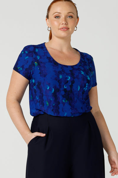 Close up of a curvy, size 12 woman wearing a cobalt abstract jersey print, Round neck top with short sleeves. A good top for summer casual wear, or style tucked as a workwear top. Shop made in Australia tops in petite to plus sizes online at Australian fashion brand, Leina & Fleur.