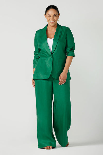 A size 12 woman wears a soft linen blazer jacket with a tailored design. A transeasonal linen work jacket, in a beautiful emerald green colour. Australian-made using sustainable 100% linen fabric. Size-inclusive fashion 8-24 for corporate casual workwear.