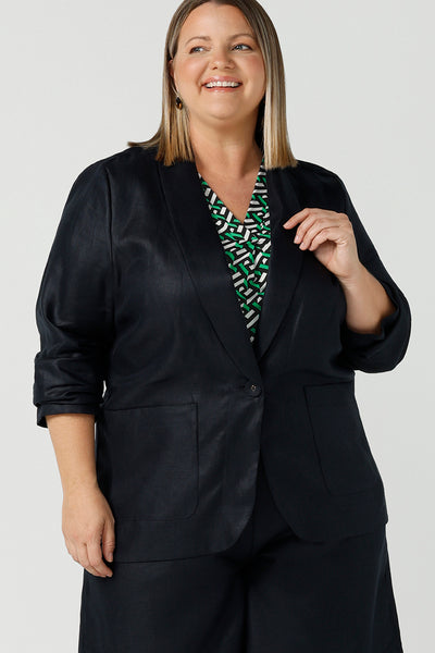 A size 18 woman wearing a 100% linen blazer jacket with a tailored design. Breathable linen fabric. This blazer has a relaxed fit a button front construction. A transeasonal linen work jacket, in a luxe midnight navy colour. Australian-made using sustainable 100% linen fabric. Size-inclusive fashion 8-24 for corporate casual workwear.